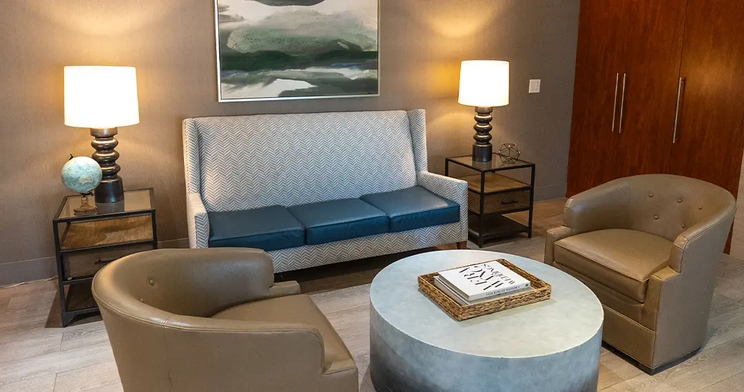 Home - Amenities2 A physical therapy or rehabilitation room with parallel bars, gym equipment, and bright overhead lights.